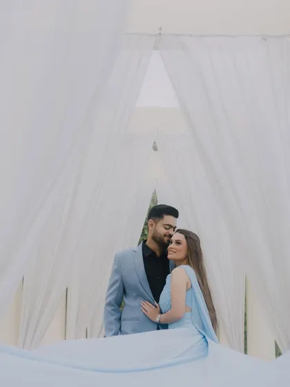 A dreamy pre-wedding portrait of Tushar and Shriya surrounded by flowing white curtains, creating an ethereal and romantic atmosphere.