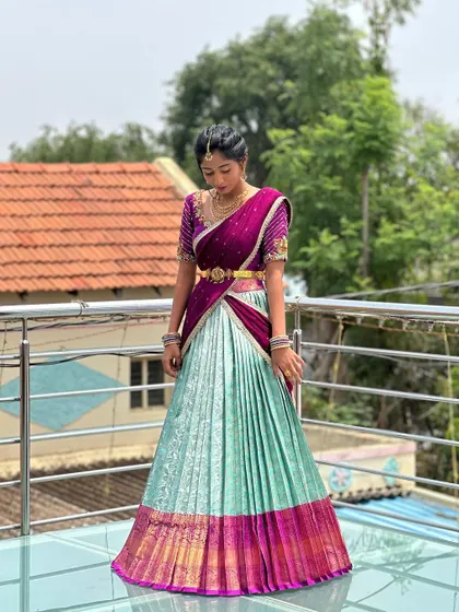 A client looking elegant in a mint green and magenta half saree with a heavily embroidered blouse.