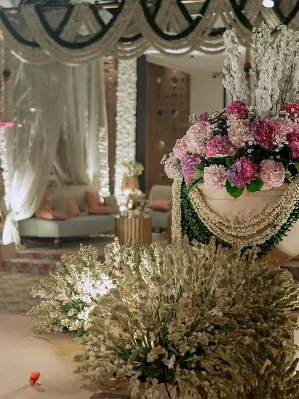 Large floral arrangements of pink hydrangeas are draped with strings of jasmine (mogra). This combination of classic English and traditional Indian flowers creates a beautiful fusion.