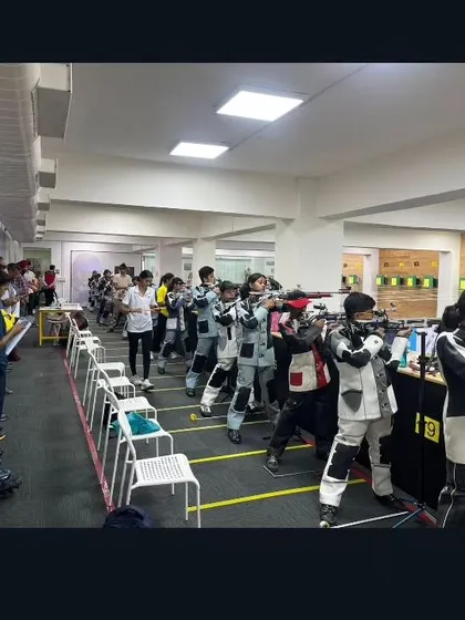 A wide view of the bustling range during the CISCE School Nationals. The gallery is filled with coaches and spectators, creating a high-pressure environment for our young athletes.