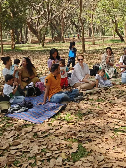 A beautiful day for a picnic and storytelling. Families spread out their blankets on the grass, ready to enjoy an afternoon of community, creativity, and connection with nature.