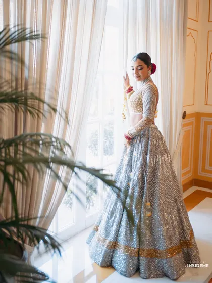 A full-length view of Mishi's stunning and contemporary bridal lehenga, complemented by a sleek bun and fresh makeup.
