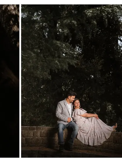 A couple sitting on a stone wall, framed by the dark shadows of the forest. This shot uses light and shadow to create a moody and artistic portrait.