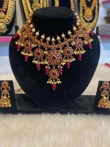 A floral-design choker set made with deep red stones. This unique piece is perfect for someone looking for a non-traditional yet ethnic look.