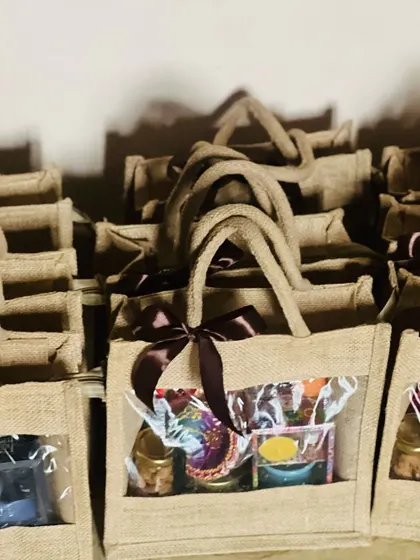 A large batch of jute bags being prepared for a corporate order, shown here in low light for a dramatic effect.