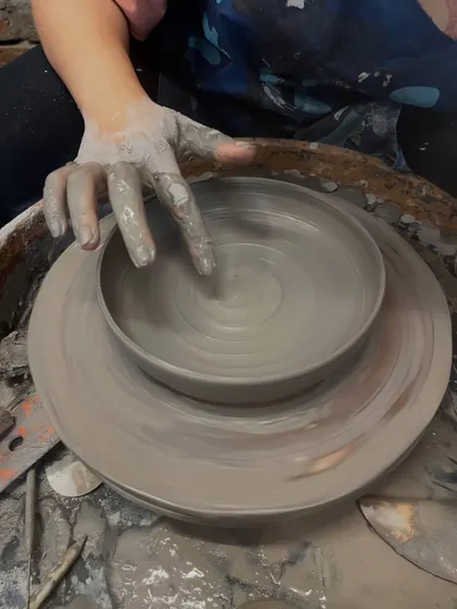 A moment captured in time. My finger gently smooths the rim of a spinning bowl, ensuring it's perfect before it comes off the wheel.