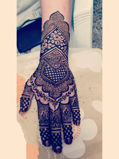 A very traditional and intricate design, featuring a heart shape filled with a checkerboard pattern and detailed work on the fingers.