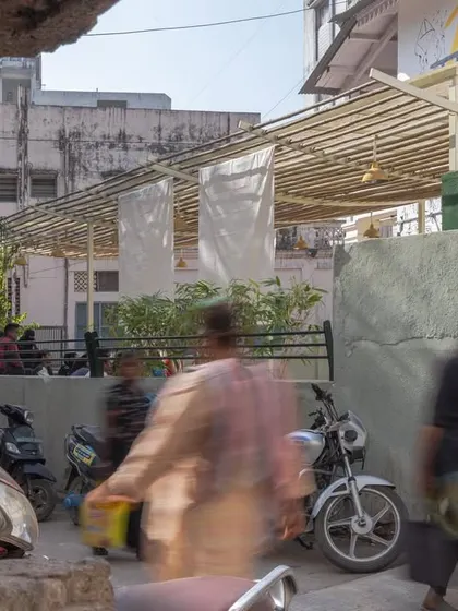A glimpse of the Basera Plaza from a distance, framed by the surrounding structures. This view emphasizes how even a small intervention can create a significant and visible public space in a dense city.