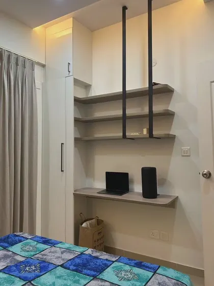 This wall-mounted workspace is perfect for a small room. The floating shelves are supported by sleek metal rods from the ceiling, creating a modern and airy look.