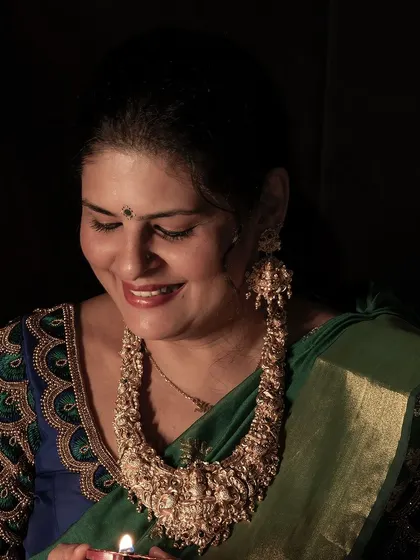 A smiling shot that captures the joy of the festival of lights. The intricate peacock embroidery on the blouse is a key detail of this custom look.