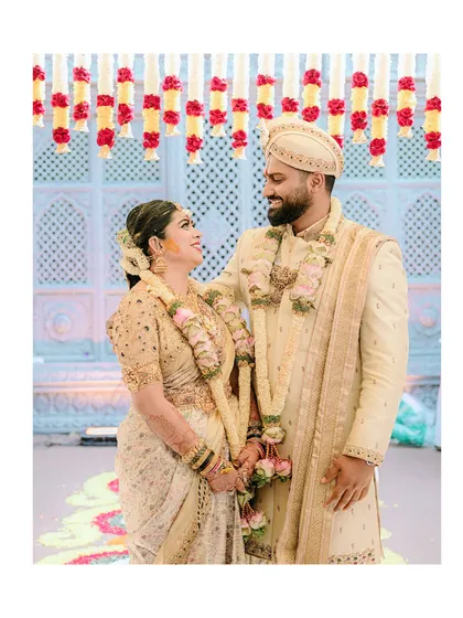 An intimate photo capturing the couple's connection. The groom's ivory sherwani and the bride's cream saree create a soft, elegant, and perfectly matched look for their wedding ceremony.