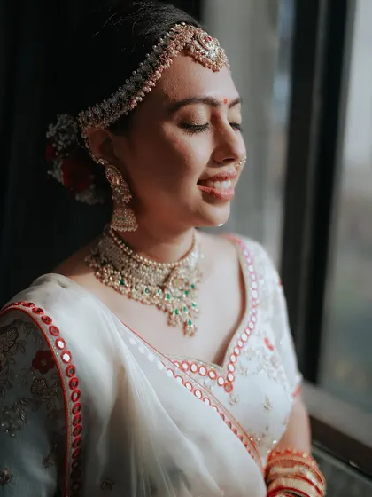 A beautiful close-up of the bride, her eyes closed in a moment of serene happiness, the sunlight catching her smile.
