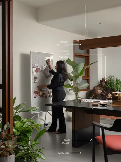 Our design process is rooted in a deep understanding of materials. Here, I am curating a mood board in our studio, surrounded by the plants and natural elements that inspire our work.