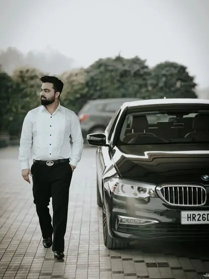 The groom's stylish entrance. This shot captures his confident walk next to a luxury car, setting a tone of modern sophistication.