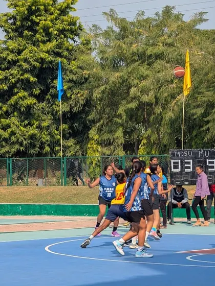 The game is in full flow. This action shot captures the intensity of the Mumbai University team during a competitive play, showcasing the fast-paced nature of inter-collegiate basketball.