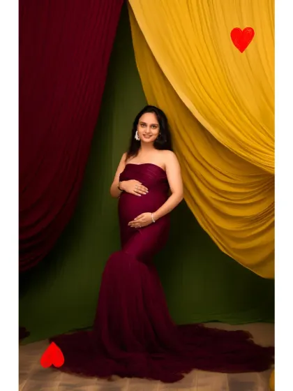 Queen of hearts. This playful and colorful studio portrait uses vibrant drapes to create a fun and memorable image for the mother-to-be.