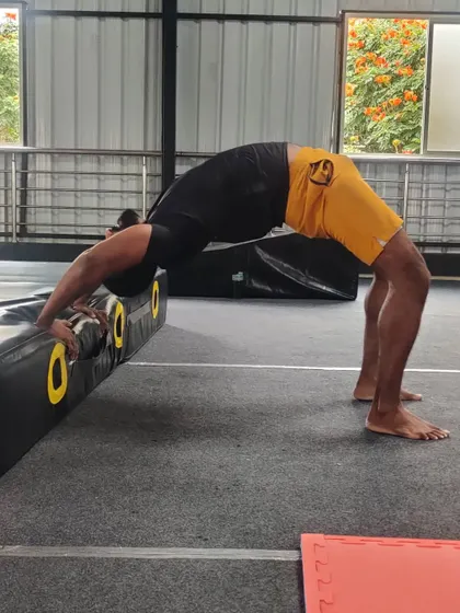 This student uses a block to support his backbend, allowing him to hold the pose longer and work on his form.