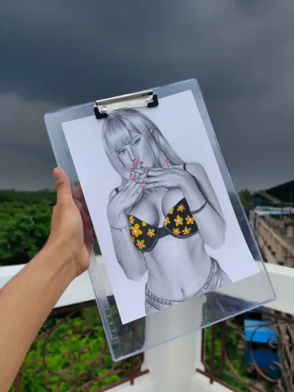 Holding up the finished Kitagawa drawing outdoors. The natural light highlights the contrast between the black-and-white sketch and the colored elements.