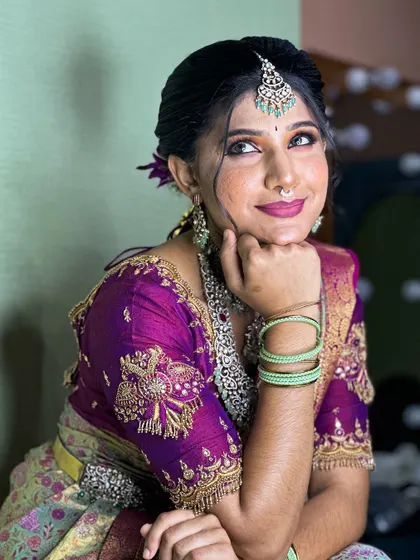 A close-up of a bride in a purple and green silk saree, showcasing the detailed silver jewelry. This look is perfect for a modern bride who appreciates traditional craftsmanship.