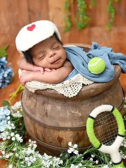 Game, set, match. This tiny tennis player, complete with a racket and ball, is dreaming of his first championship. A perfect theme for a sports-loving family.