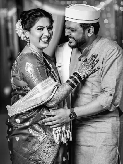 A beautiful black and white candid shot of the couple sharing a laugh, showcasing their genuine happiness.