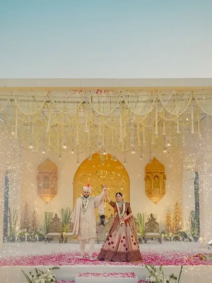 A mandap straight out of a dream. We designed this elegant stage with hanging floral strings and dramatic cold pyro effects for a truly grand Varmala entrance.