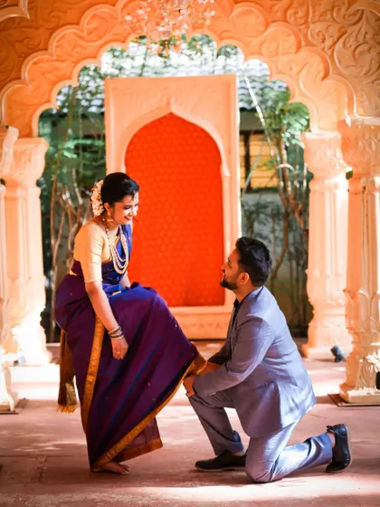 A playful and chivalrous moment from a pre-wedding shoot with the groom attending to the bride's shoe.