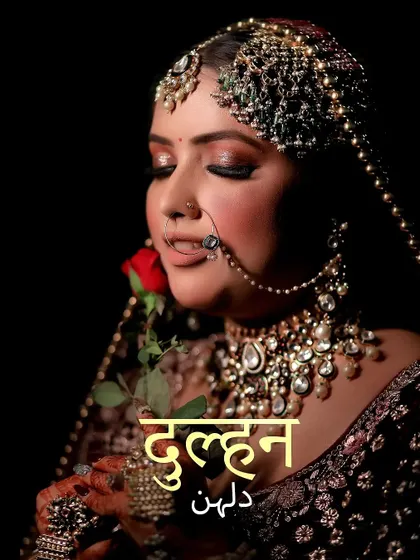 A stunning portrait of a bride holding a single red rose, her intricate jewelry and makeup perfectly captured.