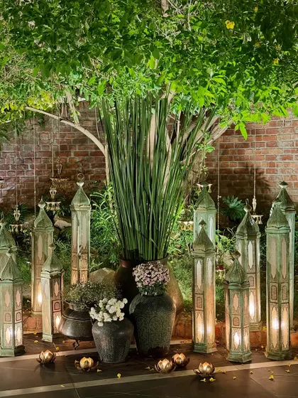 The tree styled with tall, rustic lanterns and lush green foliage for a more understated and elegant look.