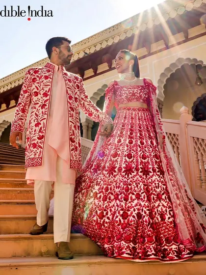 Another Incredible India feature, this one highlighting a couple in vibrant red outfits against the stunning architecture of a Rajasthan palace.