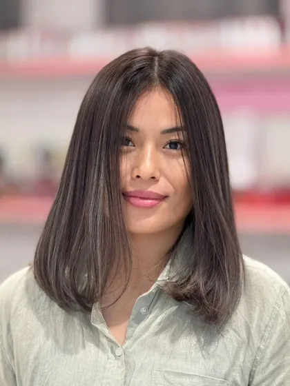 A front view of the ash hair color, showing how the subtle highlights frame her face and add a touch of brightness.