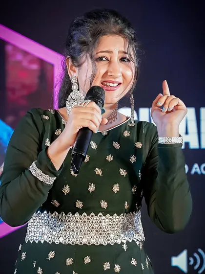 A singer performing on stage during the Ganesh Chaturthi celebrations. We are experienced in low-light and stage-light photography, ensuring crisp and vibrant images of performers.