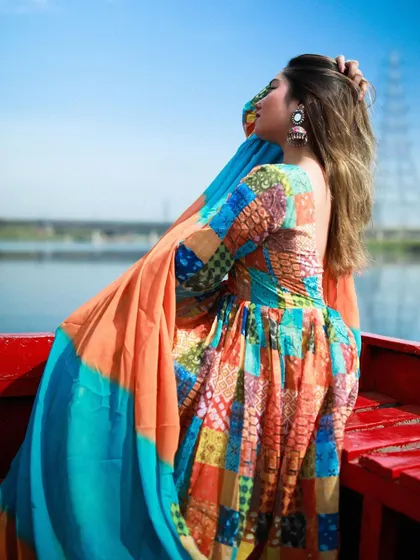 A side profile of the model in the Anarkali, capturing the flow of the dress against the river backdrop.