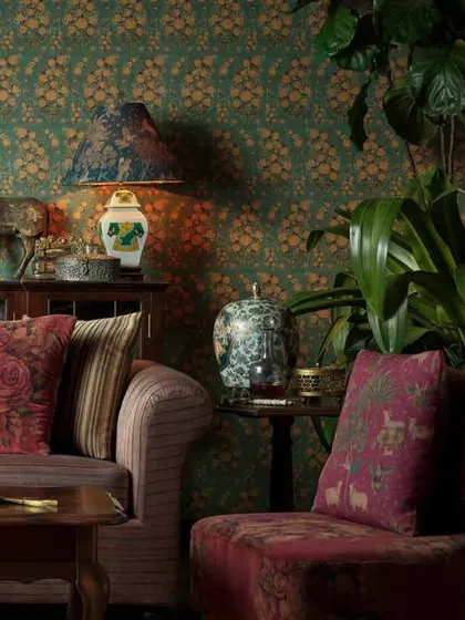 Another angle of the room with the green and gold Sabyasachi wallpaper, showing its interaction with indoor plants and rich textiles.
