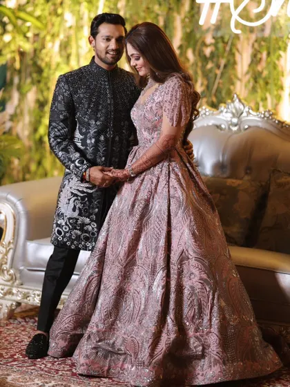 A posed portrait by their reception stage. The couple's elegant outfits and the grand decor create a look of modern royalty.