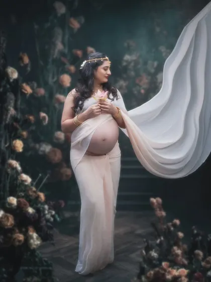 Blossoming love and beauty. This gorgeous mama-to-be radiates elegance in our specially curated floral setup, wearing a modern dhoti-style saree.