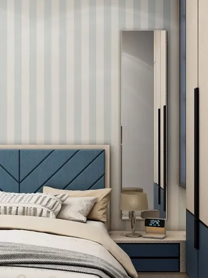 Detail of the chevron-patterned blue headboard and the sleek, full-length mirror attached to the wardrobe. These small touches add a layer of style and functionality to the room.