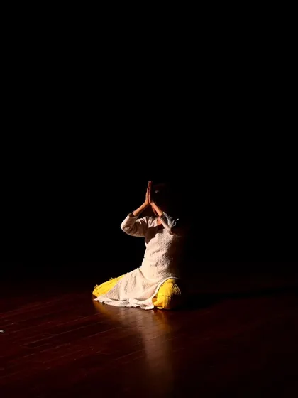 A dancer in a prayer pose during the tech run for "Immersed."