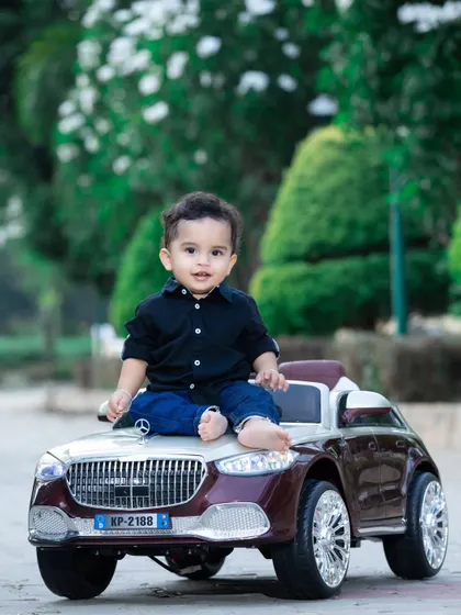 This baby is sitting on the hood of his car, looking cool and ready for a ride.