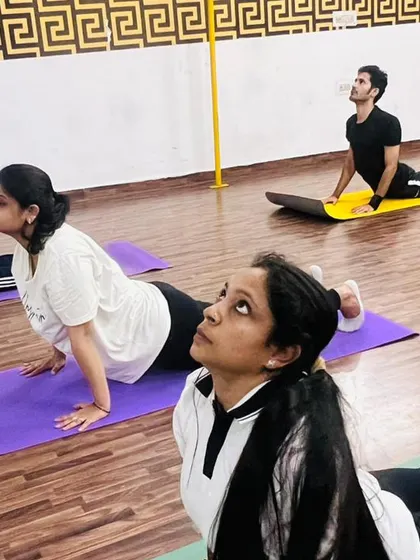 Our mixed group of men and women practicing a gentle backbend. Fitness is for everyone, and we welcome all to join our sessions.