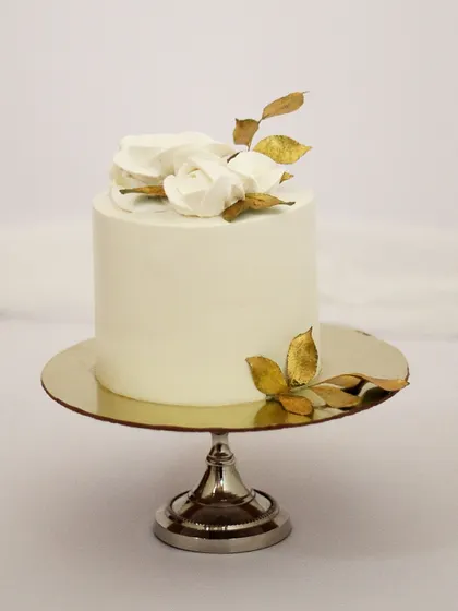 Sometimes, the simplest designs are the most elegant. This minimalist cake features a smooth white finish, accented with delicate white chocolate roses and hand-painted gold leaves. It’s a perfect centerpiece for an intimate wedding, engagement, or a special anniversary.