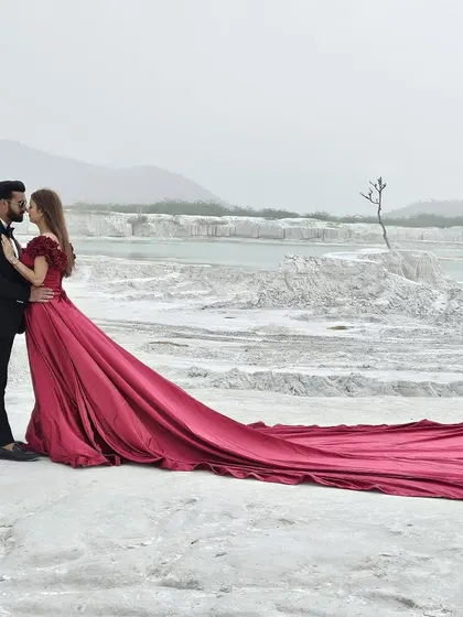 Create cinematic memories with our pre-wedding shoot collection. This dramatic red gown with a long trail is designed to look breathtaking against any backdrop, ensuring your photos are nothing short of magical.
