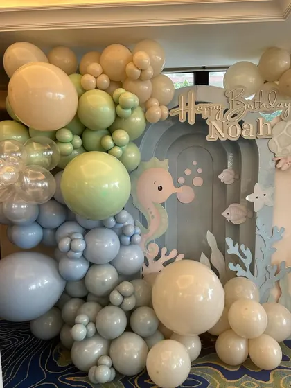 A soft and dreamy "Under the Sea" backdrop for Noah's first birthday, using a gentle pastel palette of blues and greens to create a calm and sweet ocean vibe.
