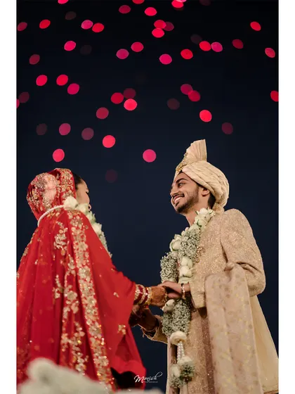 The couple shares a look under a sky of red bokeh lights, a magical and cinematic moment from their wedding night.