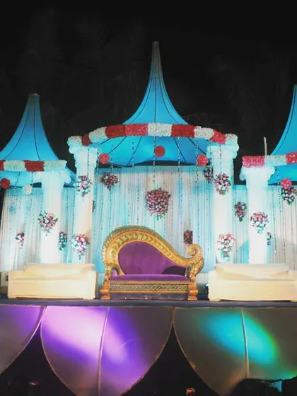 A whimsical, castle-inspired stage design with blue-topped turrets and a royal purple chaise lounge. This is for couples who want a fairytale theme for their wedding reception.