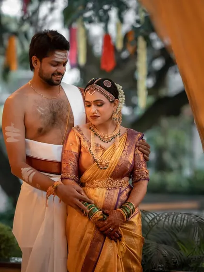 A classic portrait after the ceremony. The groom's arm around his bride, both adorned in their beautiful wedding attire, creates a timeless memory of their union.