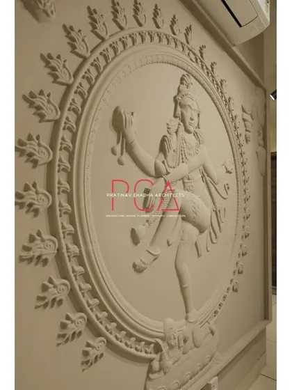 A close-up, angled view of the Nataraja wall sculpture at the Jubinav Chadha studio, highlighting the fine details of the carving.