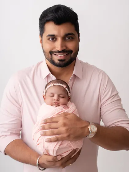 A proud father holding his newborn. This is a portrait he will cherish for the rest of his life.