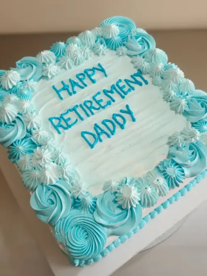 A well-lit shot of the retirement cake, showcasing the soft colors and piping work.