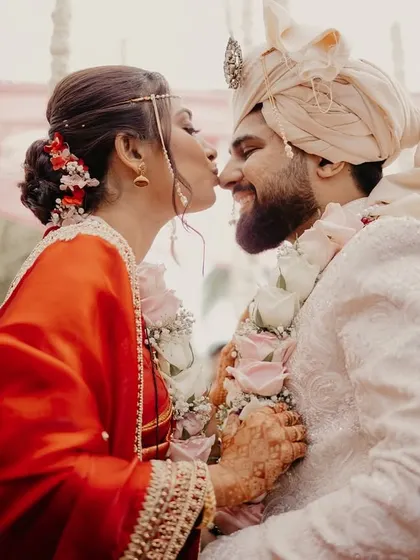 A sweet kiss on the cheek from the bride to her groom after the wedding rituals.
